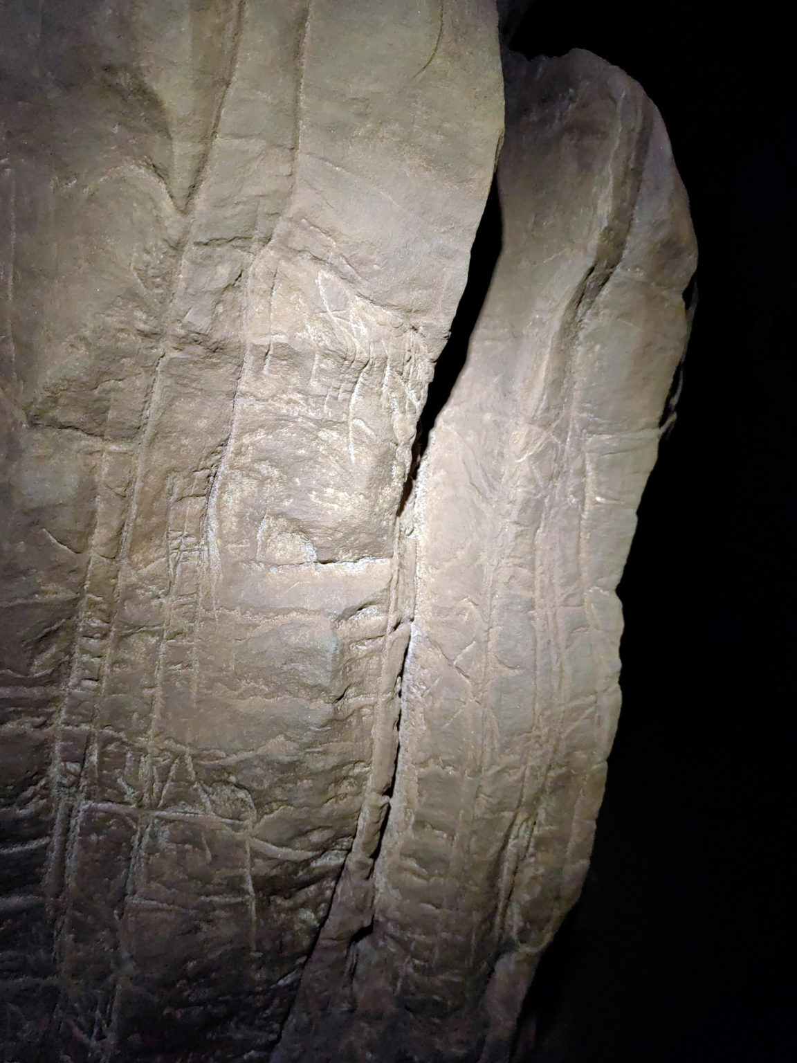 Rytiny na stene v jaskyni „Vychádzajúca hviezda" (Rising Star) v Južnej Afrike. Vedci tvrdia, že znaky vytvoril príbuzný človeka s malým mozgom, Homo naledi, pred viac ako 240 000 rokmi. Berger a kol. (2023b) via New York Times