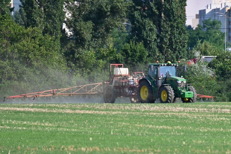 Traktor s prívesom na postrek na poli. Foto: Lukáš Grinaj/TASR