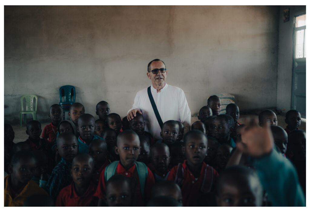 Taliansky misionár Salvatore Guerrera stojí so žiakmi v triede školy, ktorú postavil v buši, v dedine Bulige. Foto: Timotej Križka