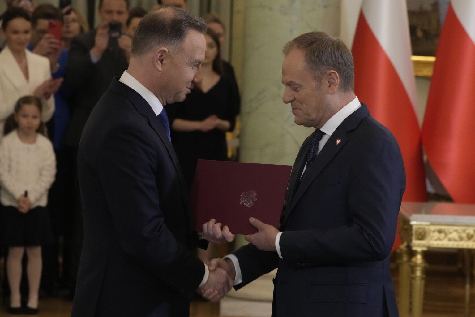 Poľský prezident Andrzej Duda (vľavo) si podáva ruku s poľským premiérom Donaldom Tuskom počas slávnostného vymenovania novej vlády vo Varšave 13. decembra 2023.
Foto: TASR/AP