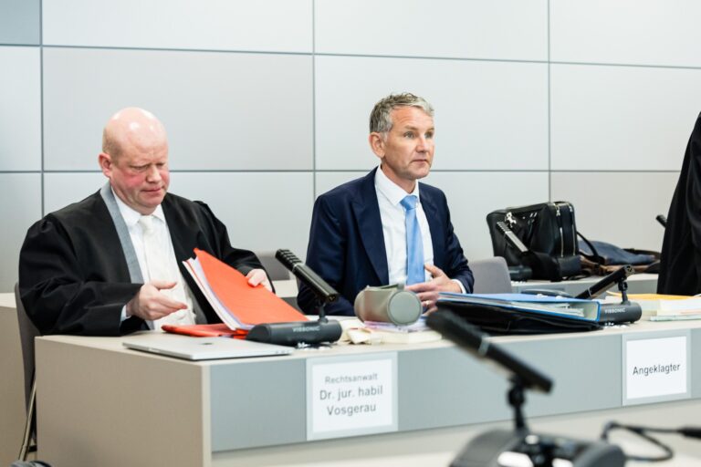 Björn Höcke, bývalý učiteľ dejepisu a súčasný líder Alternatívy pre Nemecko (AfD) v spolkovej krajine Durínsko, sedí vedľa svojho právnika Ulricha Vosgeraua počas súdneho procesu za zvolanie "Alles für Deutschland" na zhromaždení v Merseburgu v roku 2021. Foto: Profimedia.sk 
