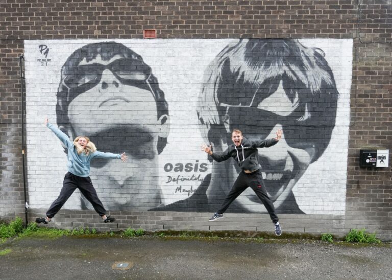 Hudobní fanúšikovia sa tešia z novej nástennej maľby s Noelom a Liamom Gallagherovcami (Oasis), ktorá je na obchode s platňami v Manchestri. Foto: Profimedia.sk