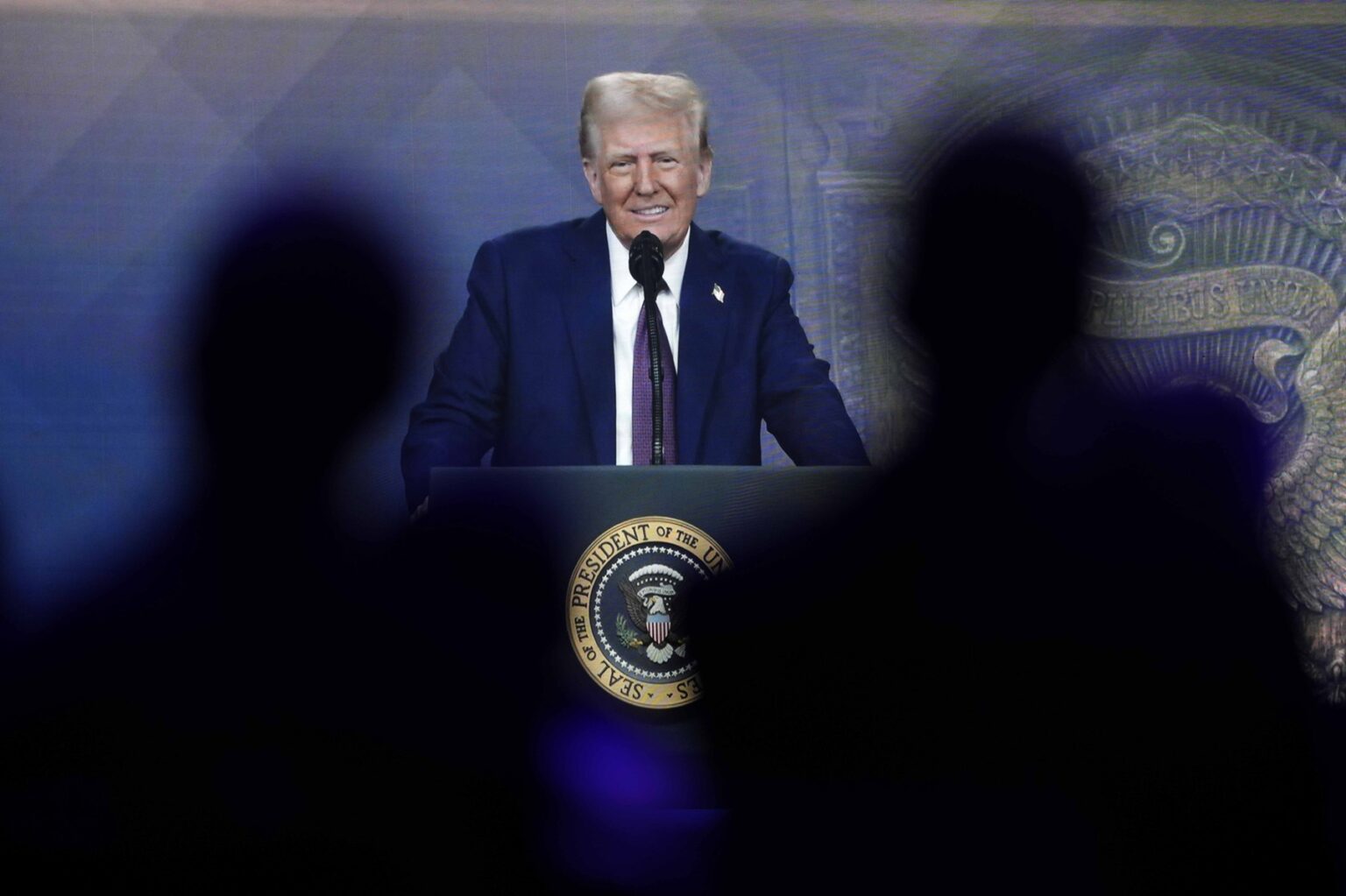 Ľudia sledujú virtuálny prejav amerického prezidenta Donalda Trumpa na výročnom zasadnutí Svetového ekonomického fóra vo švajčiarskom Davose vo štvrtok 23. januára 2025. Foto: ČTK / AP / Markus Schreiber