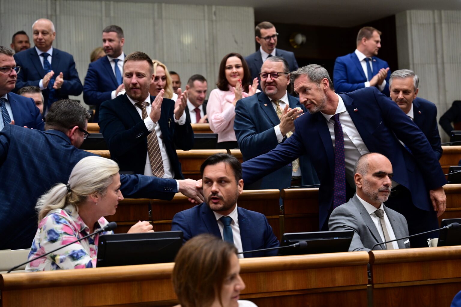Vpredu opoziční poslanci KDH a vzadu koaliční poslanci (SNS) tlieskajú po schválení novely Ústavy SR 26. septembra 2025 v Bratislave. Foto: TASR/Jaroslav Novák
