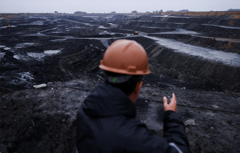 Pracovník sa pozerá na uhoľnú baňu, ktorá zásobuje surovinou uhoľnú elektráreň Candiota III v Brazílii. Foto: REUTERS/Diego Vara