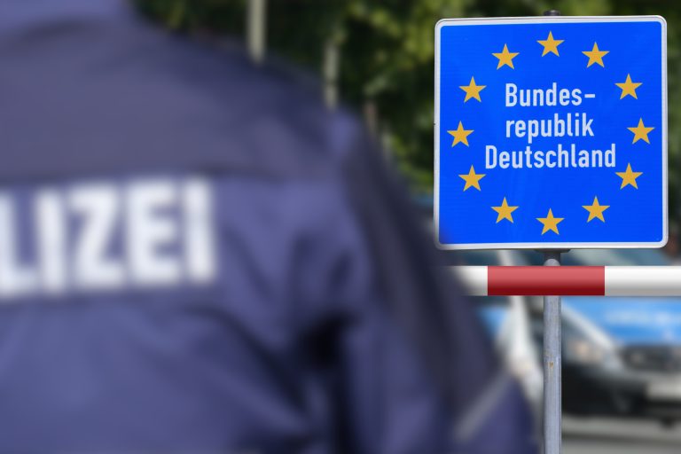 Ein Polizist steht an der deutschen Grenze vor dem Schild Bundesrepublik Deutschland. Symbolbild: Getty Images / Stadtratte