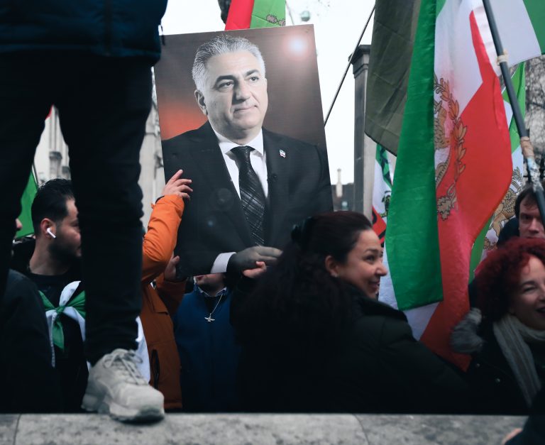Ľudia držia fotografiu Reza Pahlaviho. Foto: Alishia Abodunde/Getty Images
