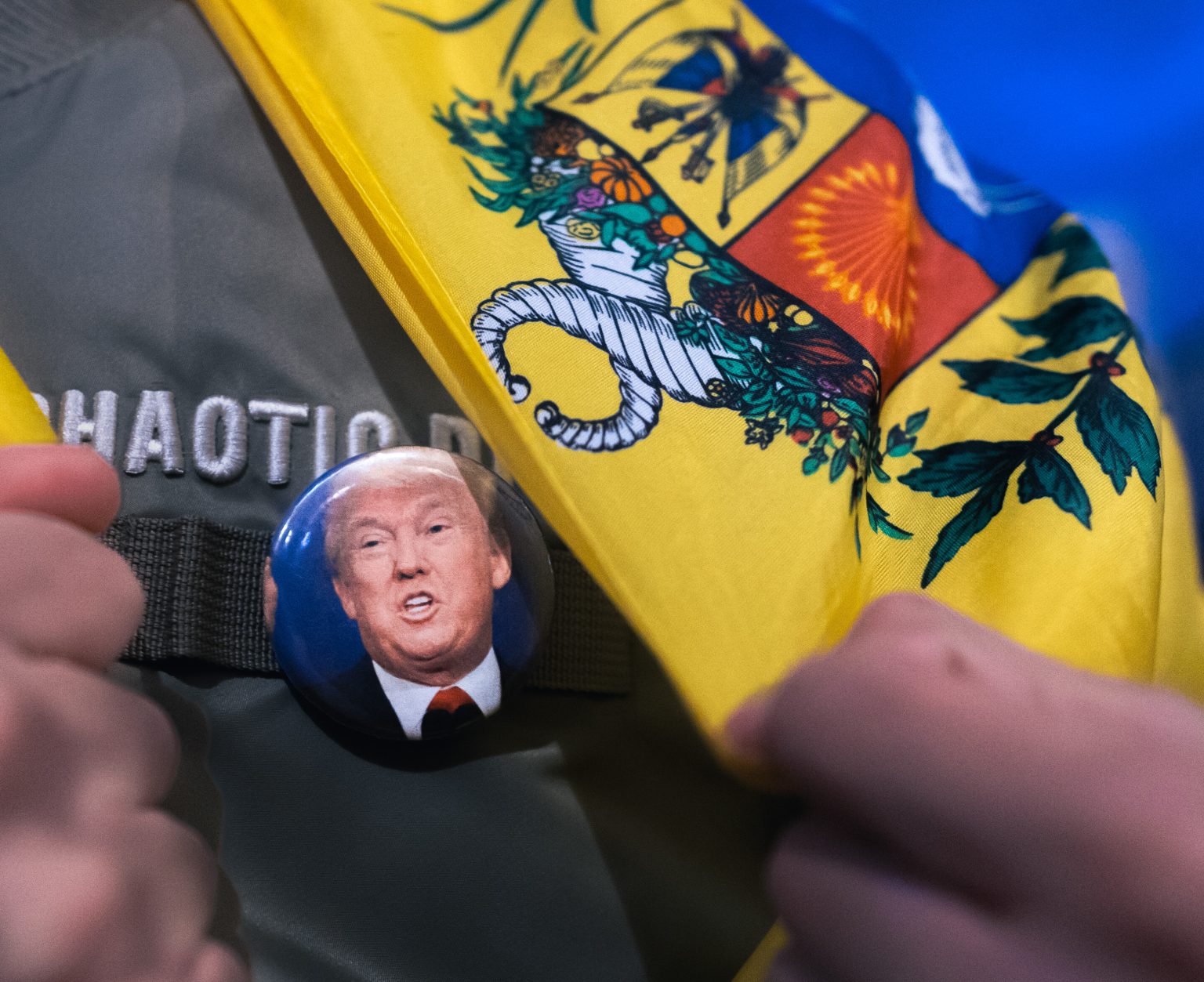 Muž nesie odznak s podobizňou amerického prezidenta Donalda Trumpa pod venezuelskou vlajkou. Foto:  Marcos del Mazo/LightRocket via Getty Images