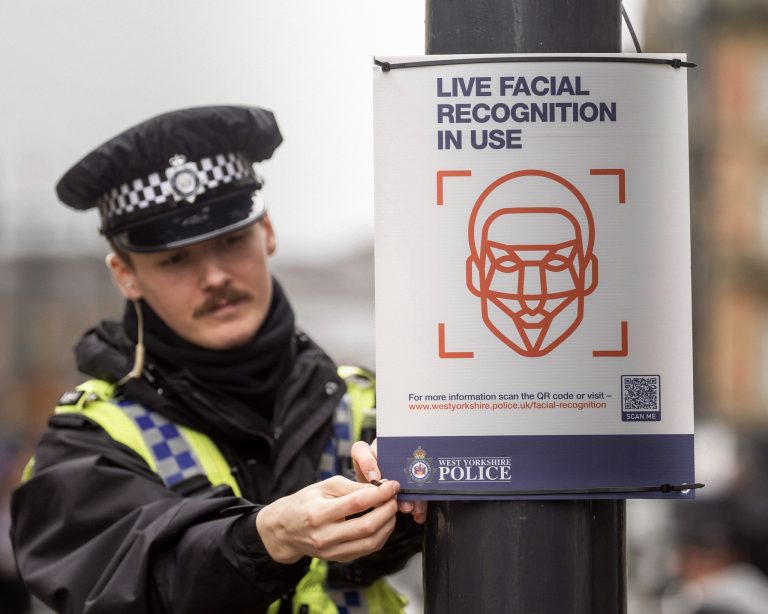 Policajt umiestňuje nápis „Používame systém rozpoznávania tváre v reálnom čase“ pri nasadení vozidla vybaveného systémom rozpoznávania tváre v reálnom čase (LFR). Foto: Danny Lawson/Getty Images