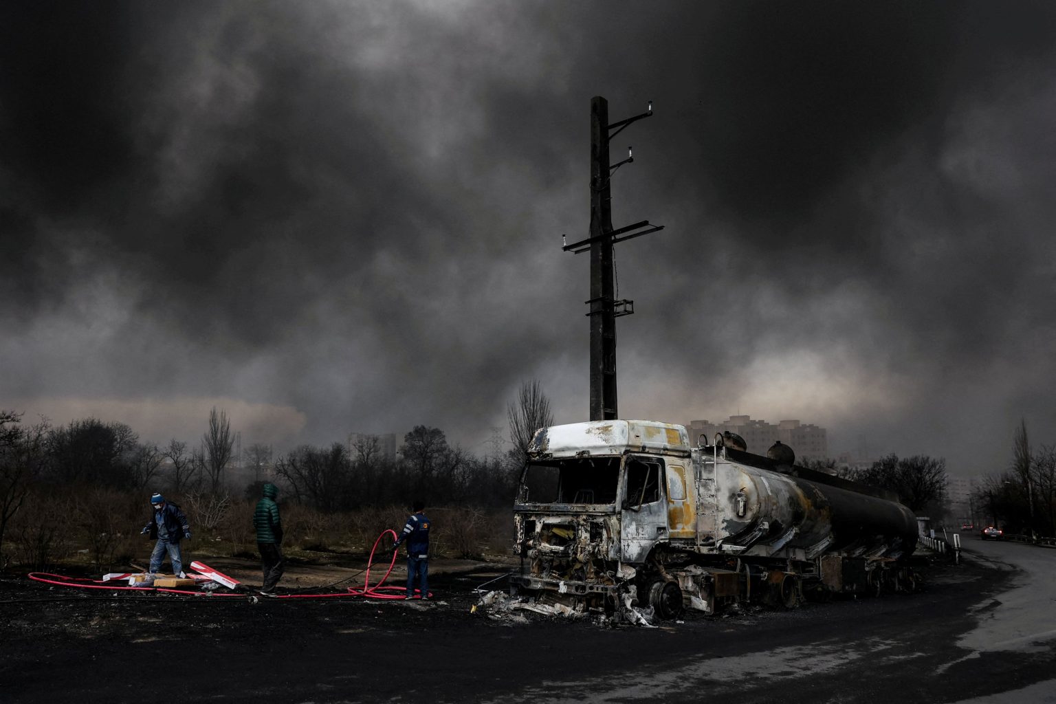 Ľudia stoja pri zničenom vozidle v Teheráne v Iráne, 8. marca 2026. Foto: Majid Asgaripour/West Asia News Agency via Reuters