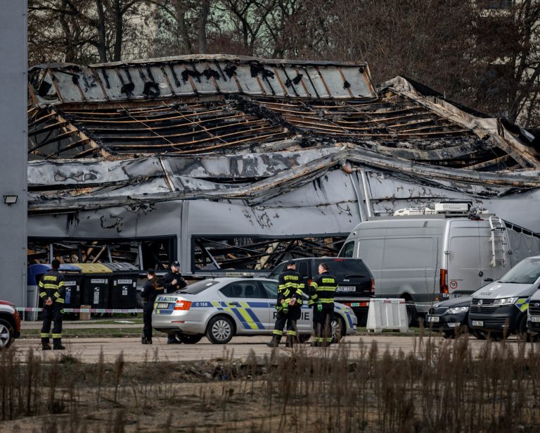 Hasiči a policajti strážia miesto, kde vyhorel sklad patriaci českej zbrojárskej spoločnosti LPP Holding v Pardubiciach. Foto: MARTIN DIVISEK/EPA/Profimedia