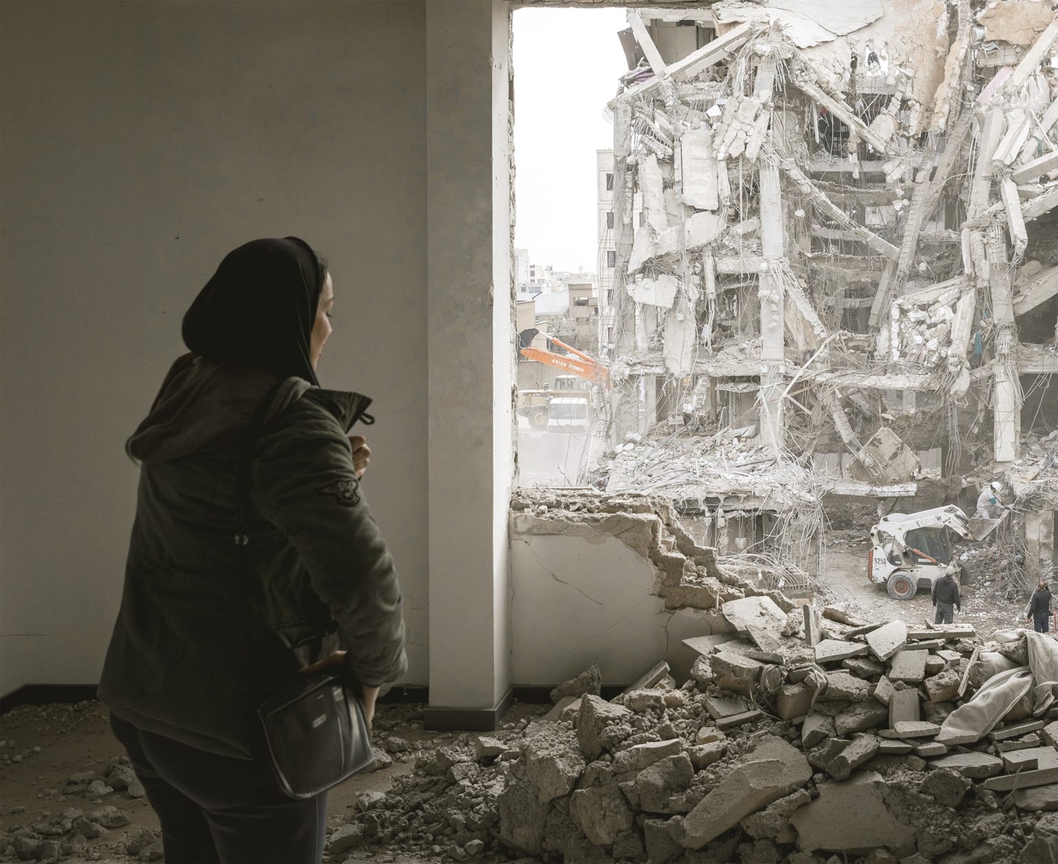 A woman looks out upon residential buildings that were destroyed a few days ago following the US and Israeli attack. Photo: Majid Saeedi/Getty Images