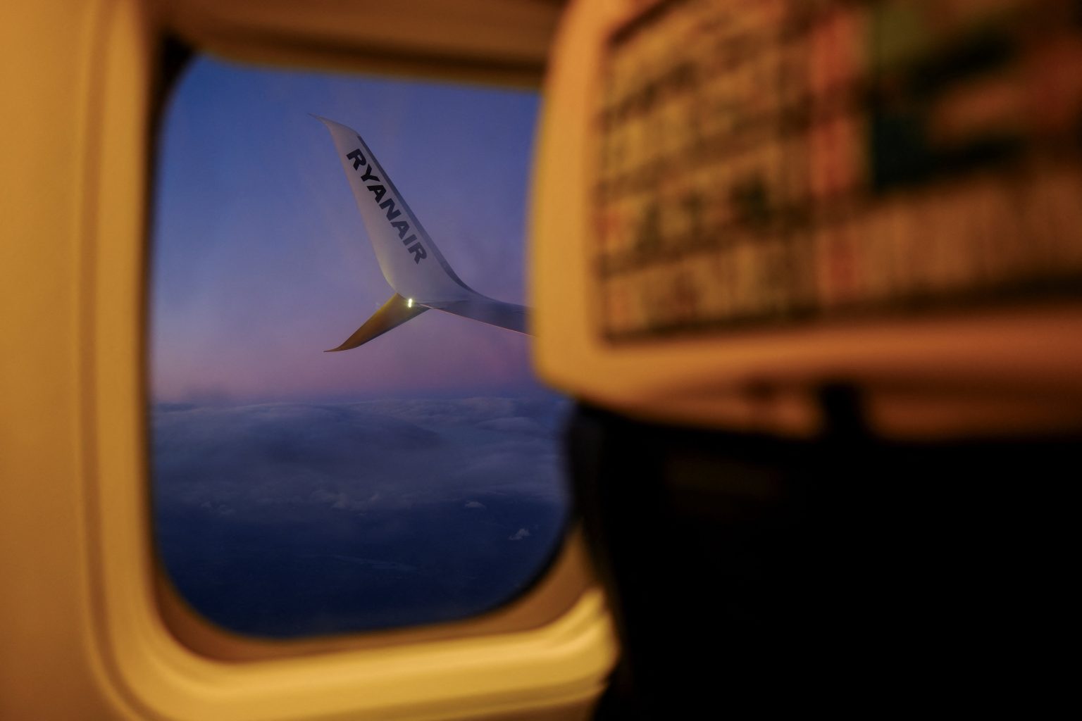 Ryanair aircraft wing seen from a cabin window at dusk. Rising aviation fuel costs are expected to push ticket prices higher. Photo: Nacho Doce/Reuters