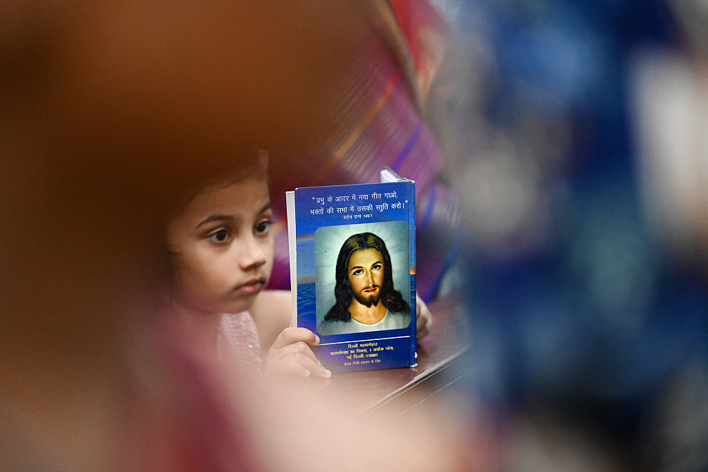 A young worshipper holds a devotional image during Easter service at Sacred Heart Cathedral in New Delhi. Photo: Sanjeev Verma/Hindustan Times via Getty Images