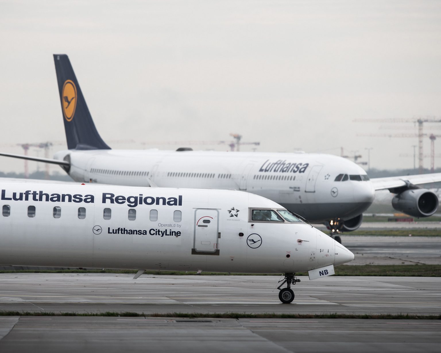 A Lufthansa CityLine passenger aircraft (front) is taxiing towards the runway at Frankfurt Airport. Photo: Silas Stein/dpa/Getty Images