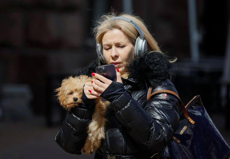 Ilustračná fotografia ženy s telefónom a slúchadlami. Foto: Gleb Garanich/Reuters