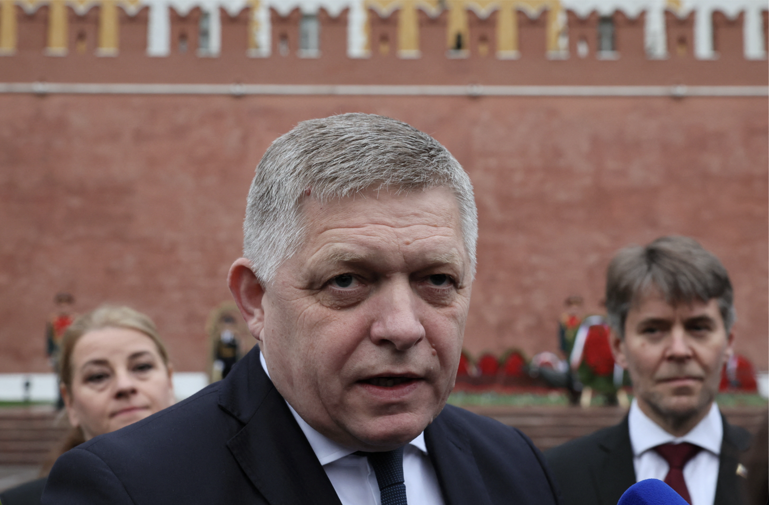 Robert Fico hovorí s novinármi po ceremónii kladenia kvetov.